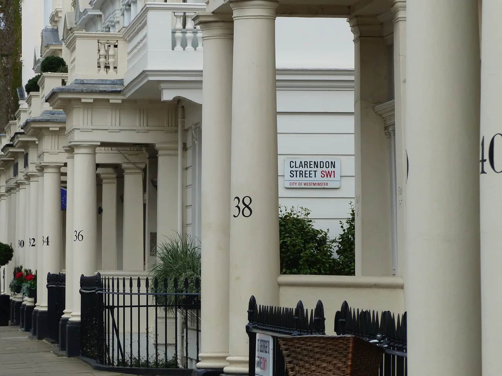 Row of Victorian London houses with decorated porches and bay windows along a quiet residential street