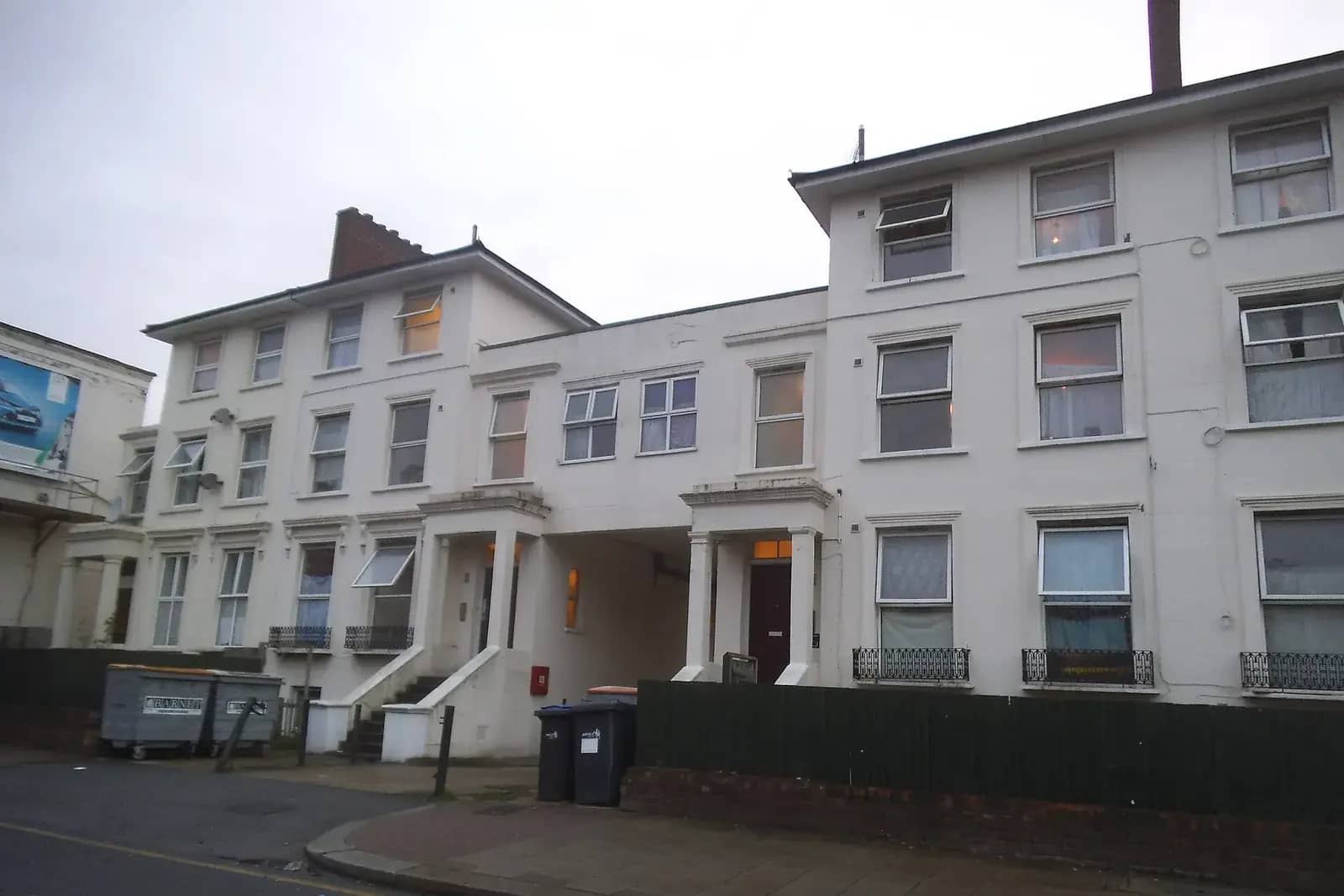 White-painted Victorian villas on Friern Barnet Road in Barnet, with bins at the kerb and a green fence