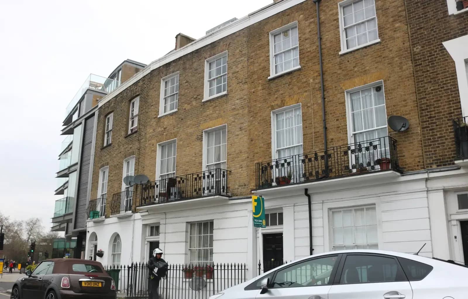 Georgian terrace on Delancey Street in Camden Town with white stucco ground floors, iron balconies and an estate agent's board