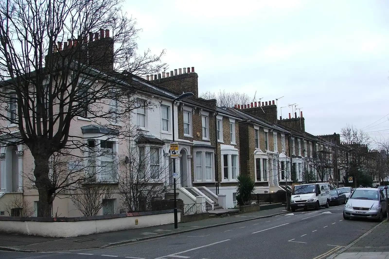 Victorian terrace on Southborough Road in Hackney with white window surrounds and tall chimney stacks, bare street trees and a white van