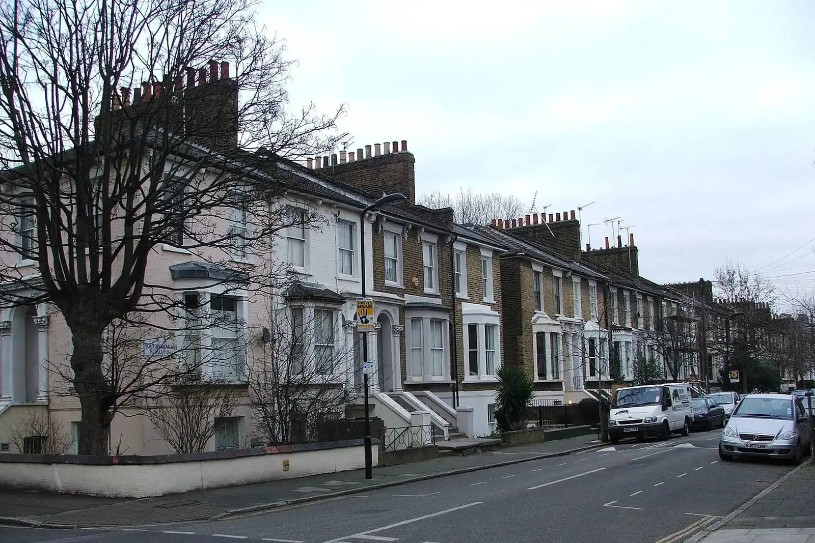 Victorian terrace on Southborough Road in Hackney with white window surrounds and tall chimney stacks, bare street trees and a white van