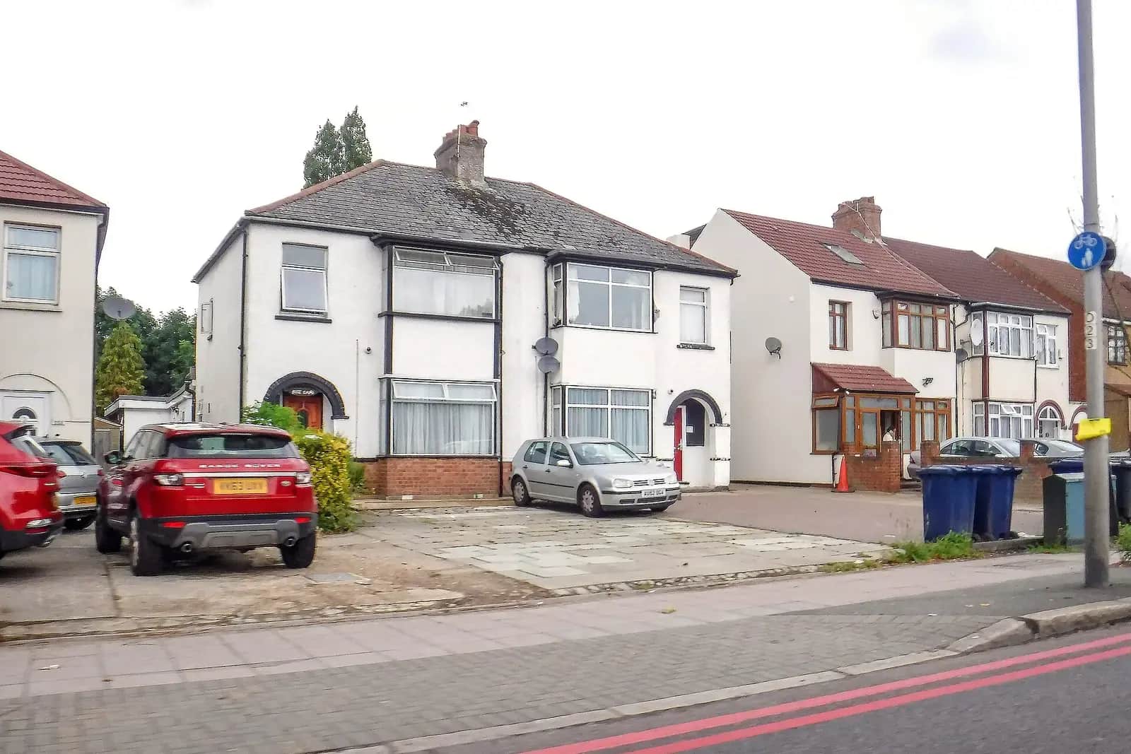 White-rendered semi-detached house on Church Road in Hillingdon with its front garden paved for parking, a red SUV outside