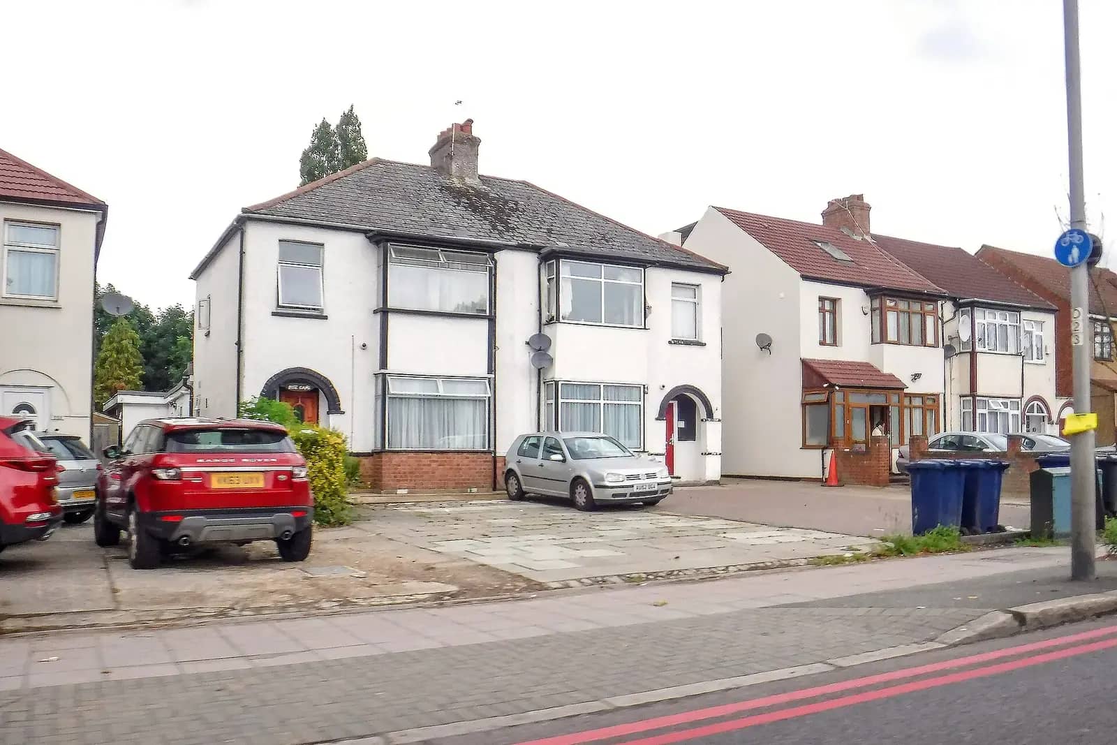 White-rendered semi-detached house on Church Road in Hillingdon with its front garden paved for parking, a red SUV outside