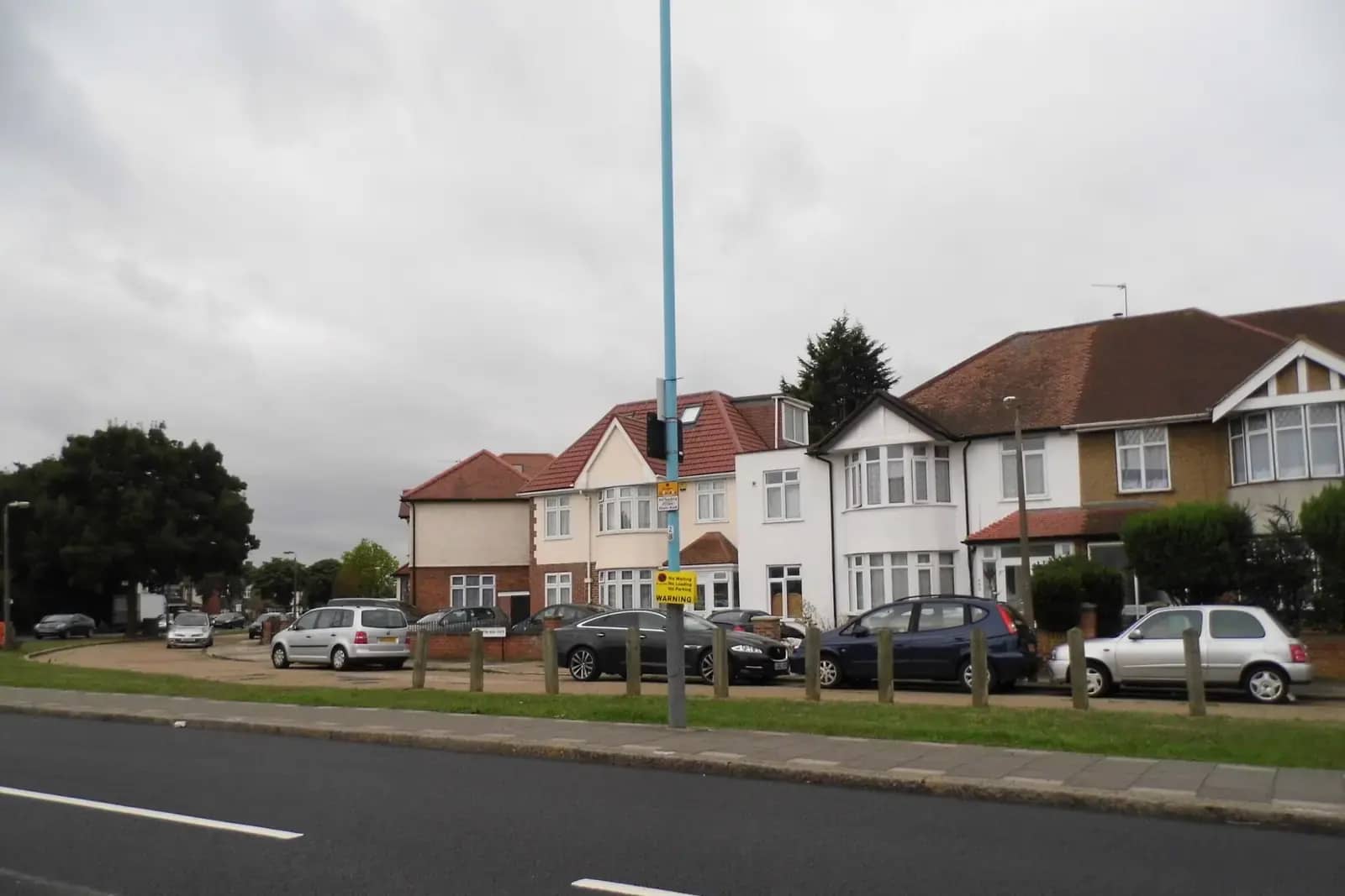Interwar semi-detached houses on Wellington Road South in Hounslow with red tiled roofs and bay windows, seen across a wide road