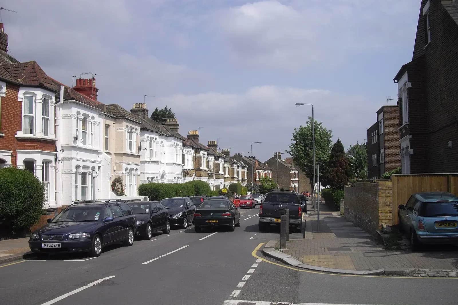 Oakhill Road in Wandsworth, a street of Victorian houses with bay windows, some painted white, and cars parked along both sides