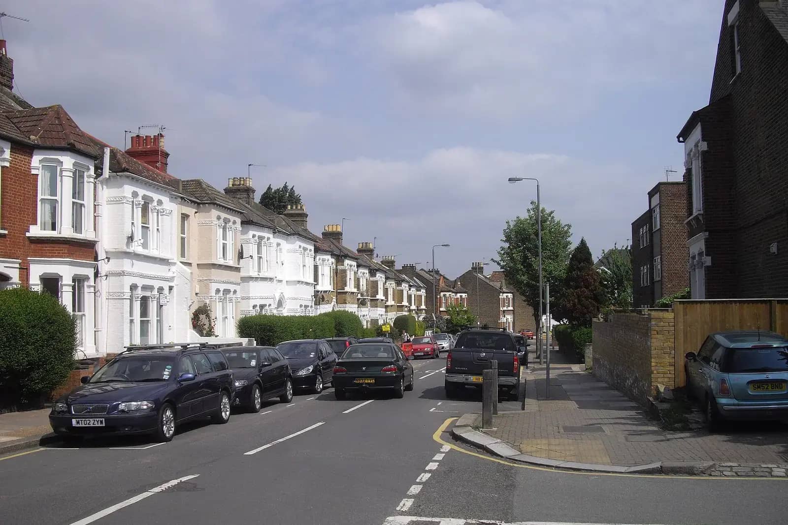 Oakhill Road in Wandsworth, a street of Victorian houses with bay windows, some painted white, and cars parked along both sides